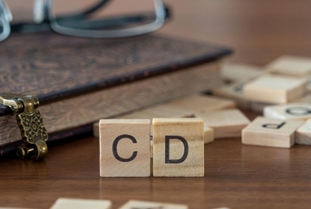 scrabble tiles spelling out cd