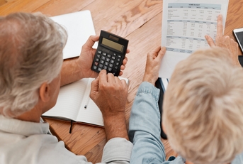 senior couple with calculator planning financial investments