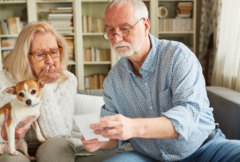 senior couple worried looking at bills