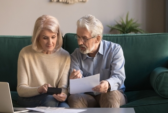 serious senior couple calculating bills