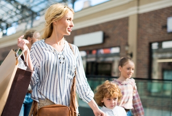 Blond woman shopping with kids at the mall