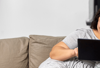 person on couch using tablet device
