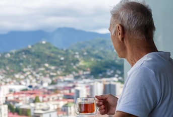 retired man viewing city on balcony