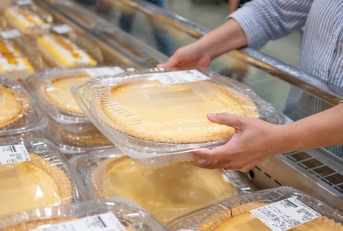 A shopper getting a pie from the grocery store