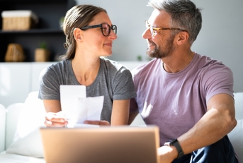 Happy couple looking at each doing paperwork