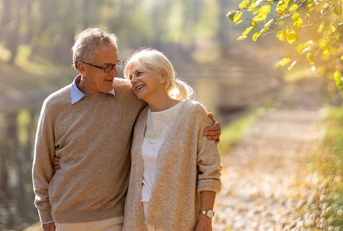 retired couple walking in autumn park