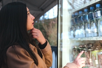 Woman shopping and looking at drinks in refrigerator 