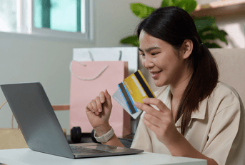 Woman with multiple credit cards and computer
