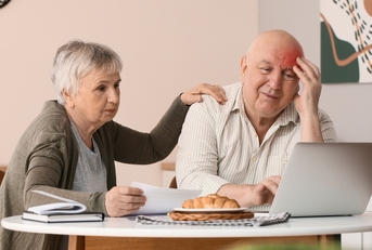 Older retired couple looking worried about bills