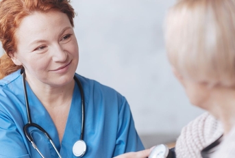 medical worker taking woman&#x27;s blood pressure