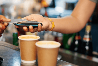 person scanning credit card at coffee shop