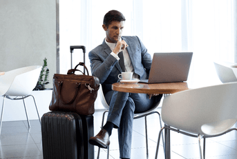 Man sitting at airport lounge with luggage
