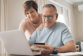 Older couple on laptop using credit card