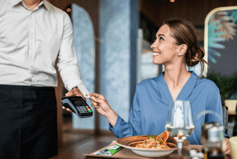 Woman using credit card at restaurant