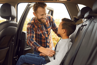 Dad buckling his son in the car