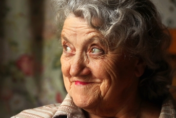 Older woman looking up smiling and thinking