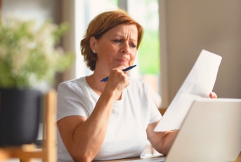 Woman looking at paperwork suspcious