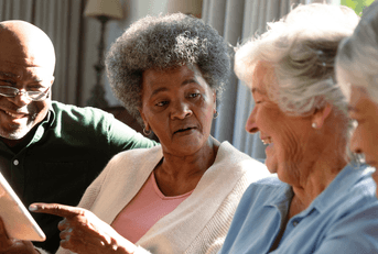 seniors sitting on couch and laughing