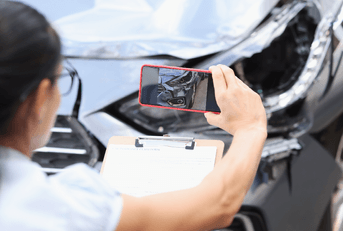 Car insurance adjuster taking photo of accident