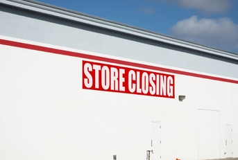 Store closing sign on building