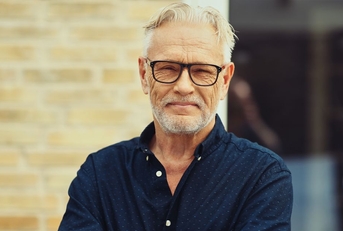 mature man in a navy shirt and glasses