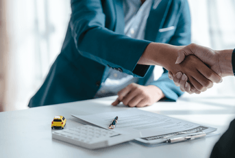Car insurance agent shaking hands over contract