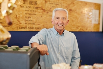 An old man working at a coffee shop