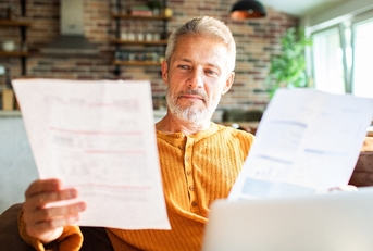 Man in his 50's looking at paperwork at home