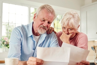 Concerned couple reviewing papers