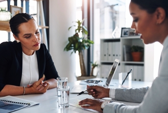 Two women reviewing documents at a table