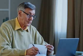 Mature man with laptop and notebook