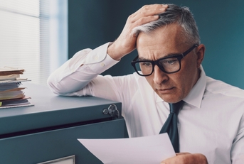 Finance man looking at document surprised and worried