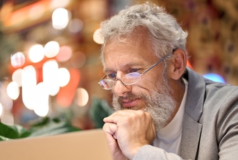 Older man reading something on the computer screen