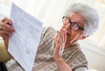 Retired senior woman looking at document worried