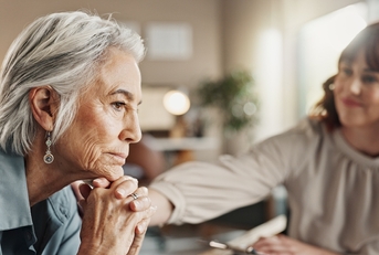 Senior woman sad being consoled by younger woman