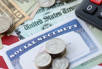 Social Security card with government check, cash, and a calculator