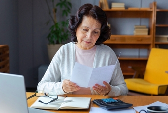 Older woman doing paperwork in her home office