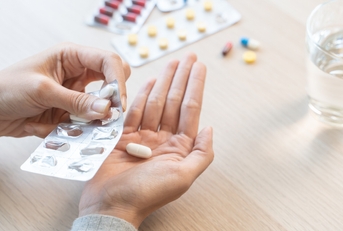 Close-Up Hands Holding Medication and Water Glass