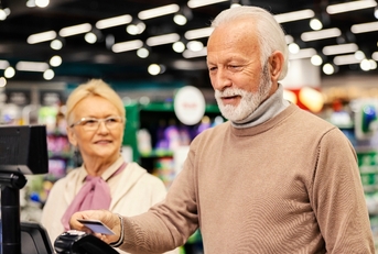 Elderly couple paying at the grocery store