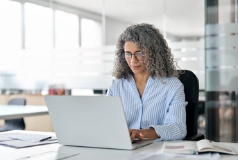 Middle aged business woman on laptop in office