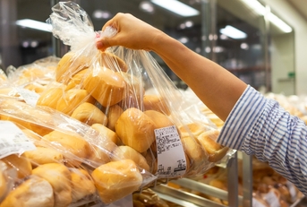 Costco Bakery shopper grabs a bag of bread rolls