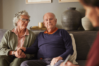 Couple looking pensive talking with advisor