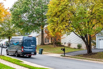 Amazon delivery van drives down streets of residential neighborhood