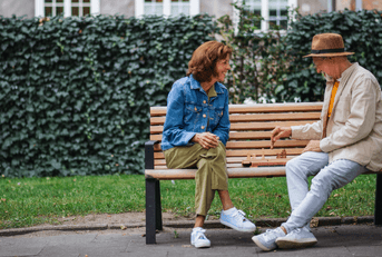 Older couple playing chess on bench