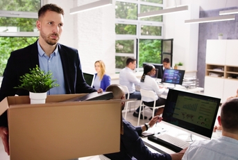 Man fired and holding box walking out of the office