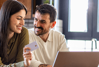 Couple using credit card on laptop