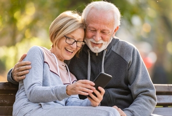 Happy retired couple on park bench