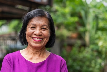 Woman in her late 60s looking at camera with a large smile