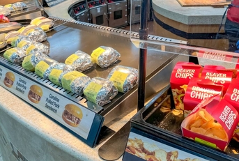 Buc-ee's food court display featuring wrapped sandwiches and Beaver Chips