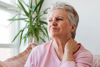 Woman in her 70s looking worried and in pain